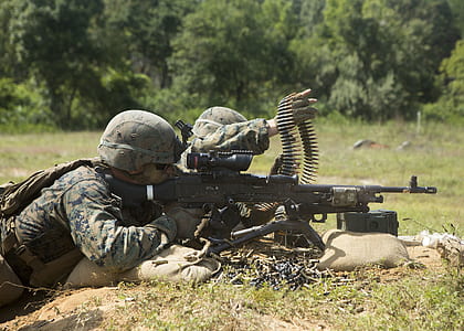 soldier holding machine gun during daytime thumbnail