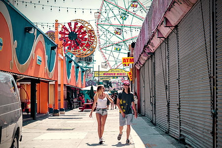 man and woman walking together beside store at daytime thumbnail