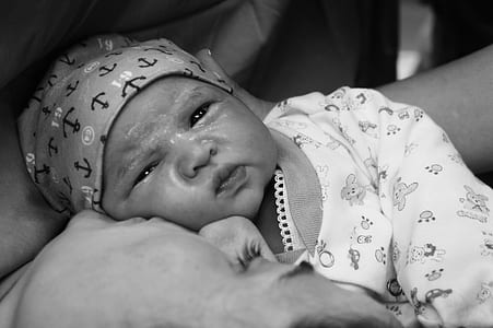 grayscale photo of baby wearing long-sleeved shirt thumbnail