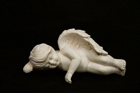 angel figurine against black background thumbnail
