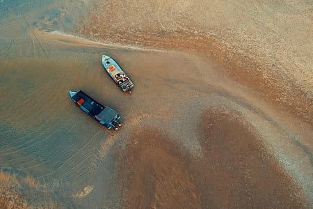 Bird's-eye View of Two Boats on Water Near Shore thumbnail