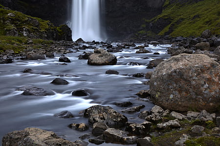 landscape photography of rocks, lake, mountains, and water falls thumbnail