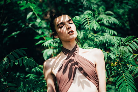 woman closing her eyes while under the shade of plant thumbnail