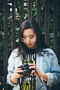 woman holding black Canon DSLR camera thumbnail