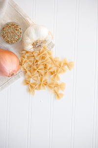 pasta and garlic bulb on white surface thumbnail