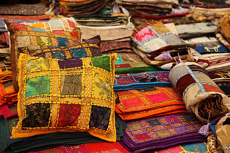 assorted-color throw pillows and blankets on ground thumbnail