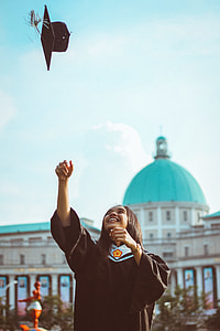 woman tossing her graduation hat thumbnail