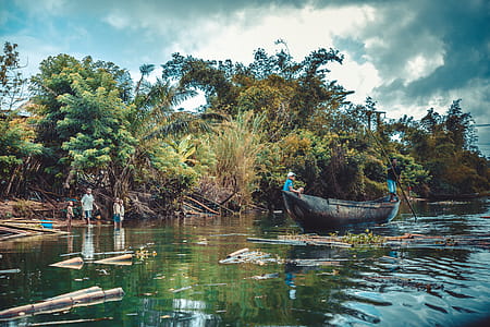 Person Riding on Black Wooden Boat thumbnail