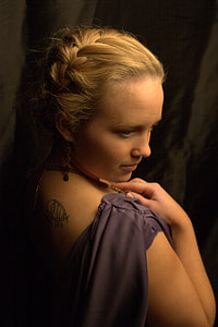 woman in purple sleeveless top with black back tattoo thumbnail