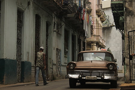 man walking on street beside taxi thumbnail