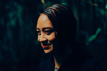 Portrait shot of an Asian woman’s face with smile in forest thumbnail
