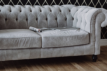 Elegant grey sofa with a laptop, an iPhone and a magazine thumbnail