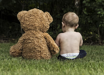 toddler sitting together with brown bear plush toy thumbnail