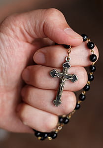 person holding black rosary thumbnail
