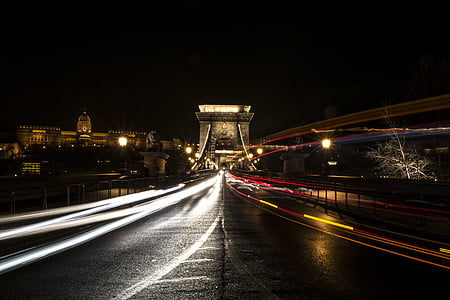 timelapse photography of vehicle lights near buildings thumbnail