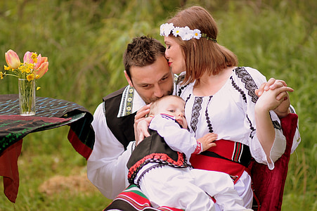 woman carrying baby kissing man thumbnail