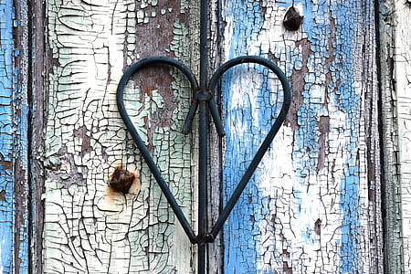 black wrought iron heart on white and blue wooden surface thumbnail
