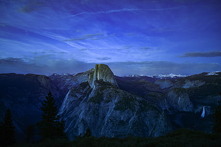 green trees and mountain under night time thumbnail