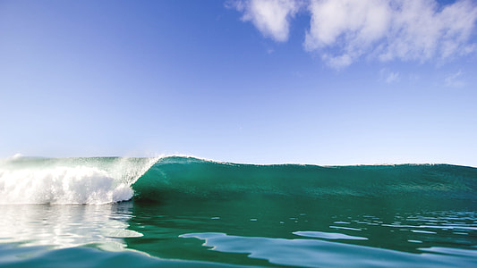 ocean wave under blue and white cloudy sky thumbnail