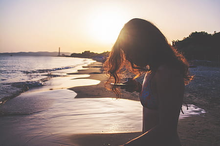 woman in blue and red bra standing on brown sand during sunset thumbnail