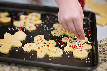 toddler sprinkling candies on cookie emulsion thumbnail