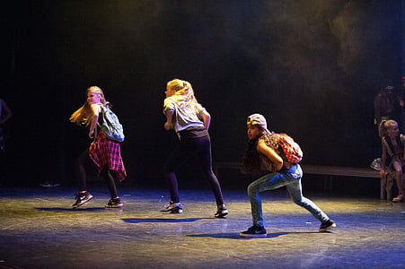 three women dancing on stage white wearing backpack thumbnail