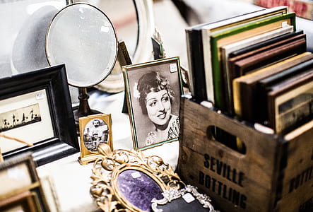 books beside photo frames and mirror on white surface thumbnail