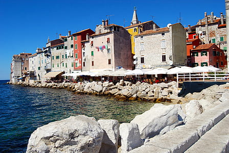 gray concrete buildings near body of water thumbnail