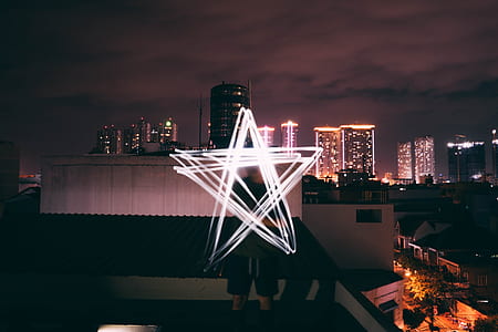 man standing on rooftop under black sky thumbnail