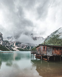 brown wooden house below body of water at daytime thumbnail