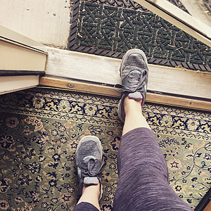 person wearing brown sport tights and gray sneakers standing on open door thumbnail