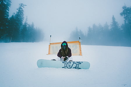 man sitting on snowfield in front snowboard thumbnail