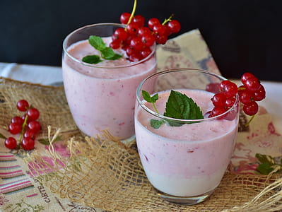 two clear goblet glasses with orange liquid and red berries thumbnail