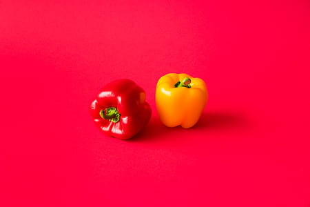 Red and Yellow Paprika Peppers on Flat Background Still Life thumbnail