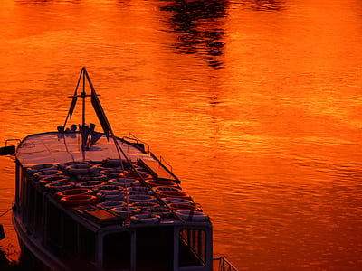 boat on rippling orange water thumbnail