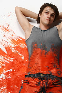 man wearing gray tank top covered with red paint thumbnail