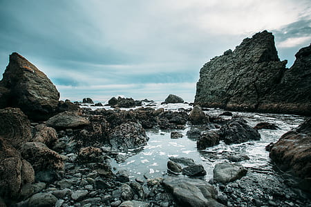 photography of running water beside two rocks thumbnail