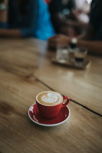red ceramic coffee cup on red ceramic saucer plate thumbnail