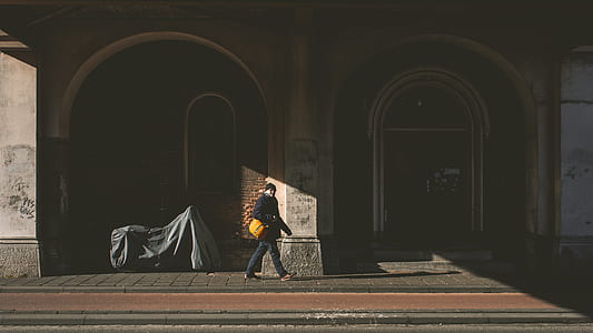 man walking on black concrete pavement thumbnail