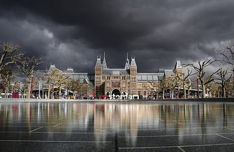 brown building under dark cloudy sky thumbnail