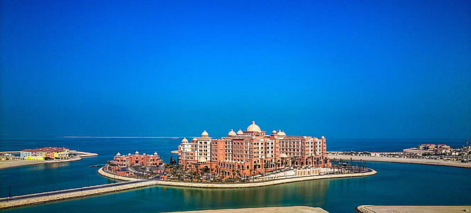 view of brown building surrounded by body of water thumbnail