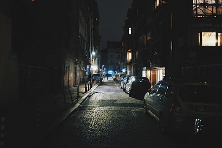 assorted-color parked cars between buildings thumbnail