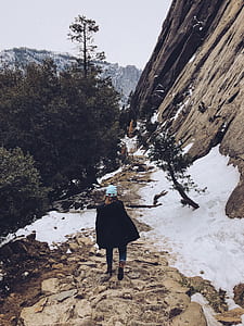 woman walking towards snow-covered mountain thumbnail