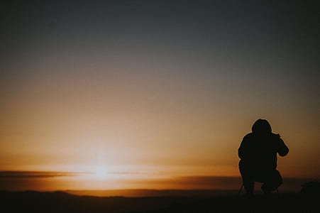 silhouette of person during orange sunset thumbnail