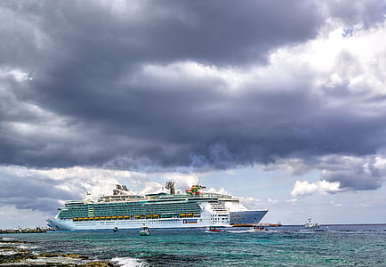 white and green cruise ship on water under grey cloudy sky thumbnail