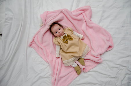 toddler lying on pink textile thumbnail