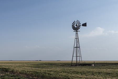 gray windmill on grass field thumbnail