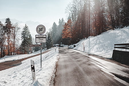 road sign near road during winter season thumbnail
