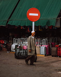 man in brown coat walking on street during daytime thumbnail