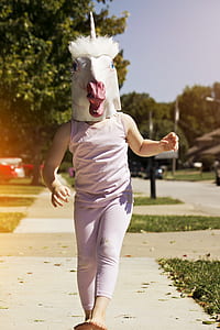 toddler wearing purple tank top and pants wearing Unicorn head mask thumbnail